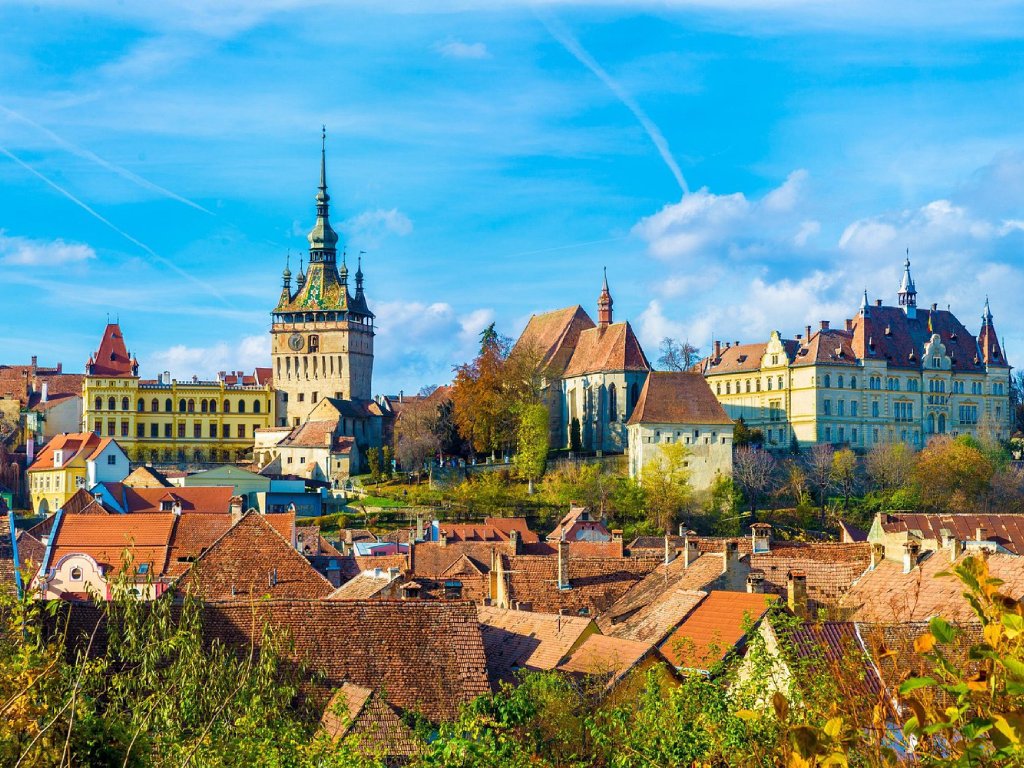 As you roll into Sighișoara, the citadel rises into view above a sea of red rooftops.