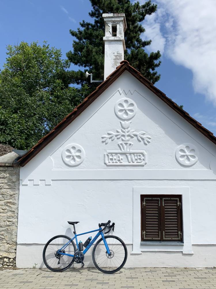A road bike leaning against a white press house in the Balaton Highlands