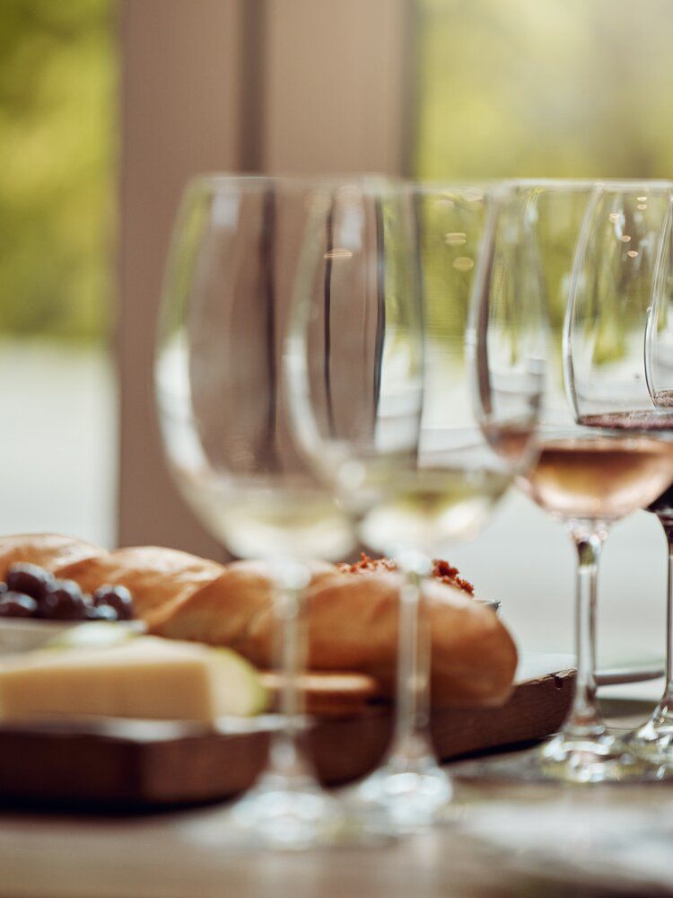 A row of wine glasses and a cheeseboard set out for a tasting