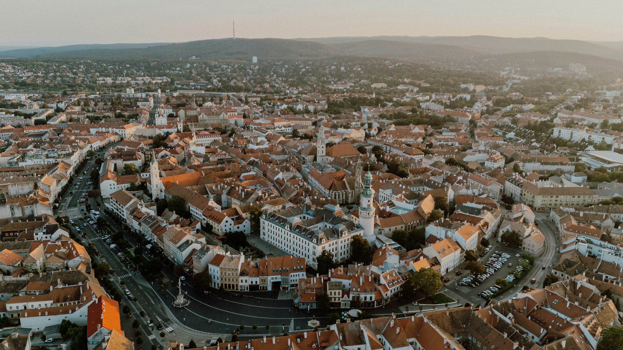 Aerial view of the red rooftops and church towers of Sopron old town